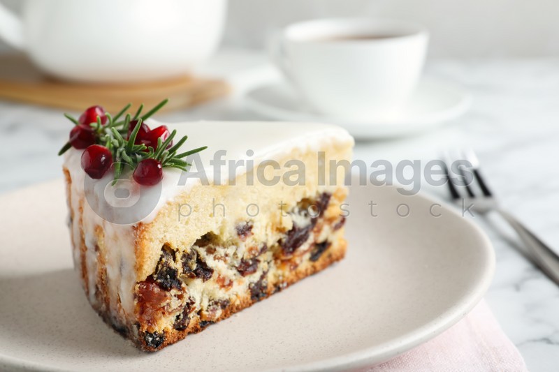 Photo of Slice of traditional Christmas cake decorated with rosemary and pomegranate seeds on table, closeup