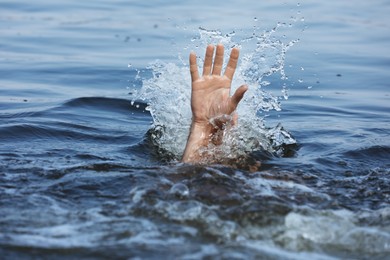 Drowning man reaching for help in sea, closeup