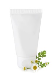 Tube of hand cream and chamomiles on white background