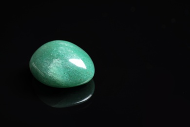 Photo of Beautiful aventurine gemstone on black background. Space for text