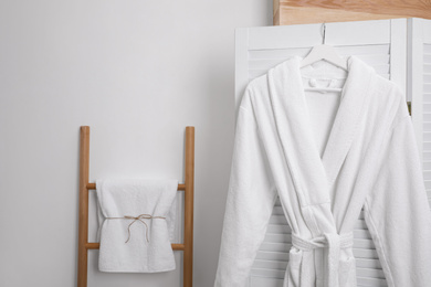Hanger with clean soft bathrobe on screen