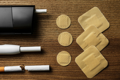 Flat lay composition with nicotine patches and cigarettes on wooden table