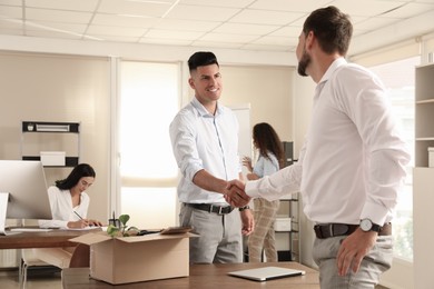 Photo of Employee shaking hand with new coworker in office