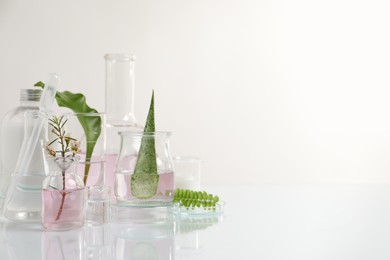 Organic cosmetic product, natural ingredients and laboratory glassware on white table, space for text