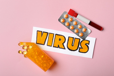 Flat lay composition with word VIRUS and medicines  on pink background