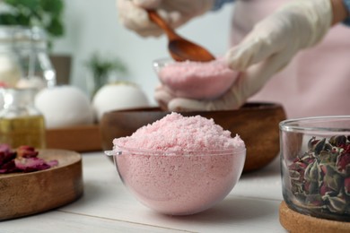 Pink bath bomb mixture in mold and blurred view of woman on background