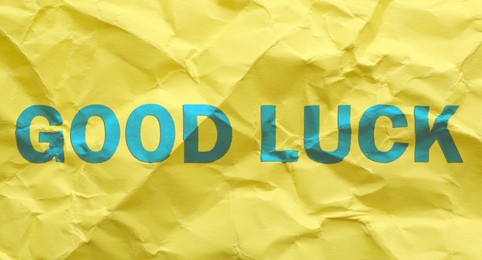 Image of Phrase GOOD LUCK on yellow crumpled paper, top view