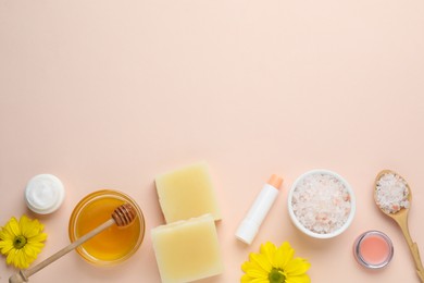 Flat lay composition with beeswax and cosmetic products on beige background. Space for text