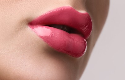 Woman with beautiful perfect lips after permanent makeup procedure on light background, closeup