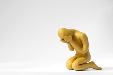 Plasticine figure of crying human on white background. Space for text