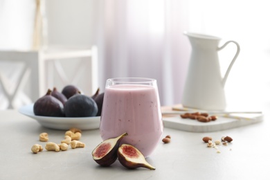 Delicious fig smoothie in glass on light table