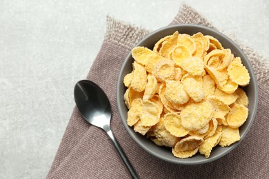 Bowl of sweet crispy corn flakes on light grey table, flat lay. Breakfast cereal