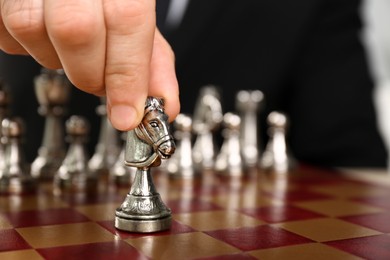 Man moving chess piece on board, closeup