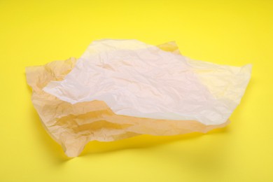 Photo of Sheets of crumpled baking paper on yellow background