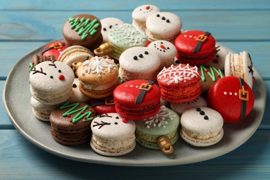 Beautifully decorated Christmas macarons on light blue wooden table