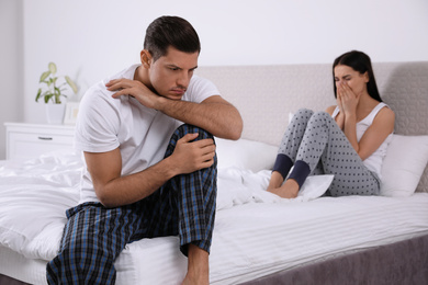 Unhappy couple with relationship problems after quarrel in bedroom