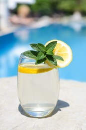 Refreshing water with lemon and mint on rock outdoors