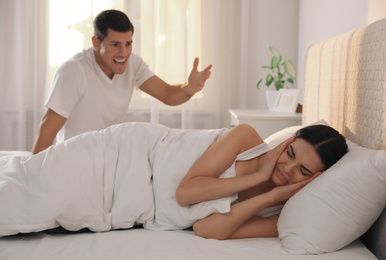 Couple with relationship problems quarreling in bedroom