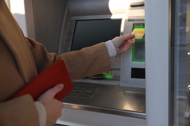 Young woman using cash machine for money withdrawal outdoors, closeup