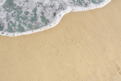Beautiful foamy sea tide on sandy beach
