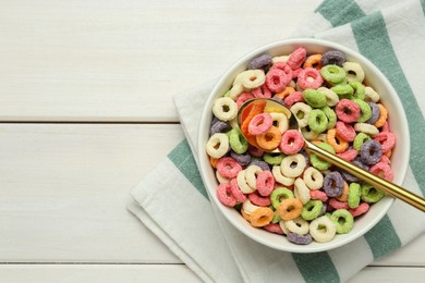 Bowl of sweet crispy corn rings on white wooden table, flat lay with space for text. Breakfast cereal
