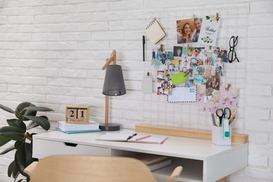 Stylish workplace with stationery and vision board