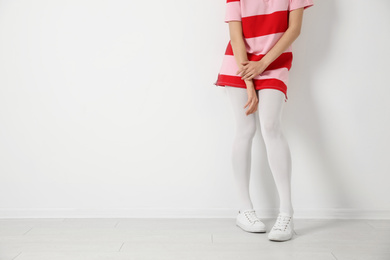 Photo of Woman wearing tights near white wall, closeup. Space for text