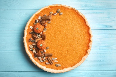 Delicious homemade pumpkin pie on light blue wooden table, top view