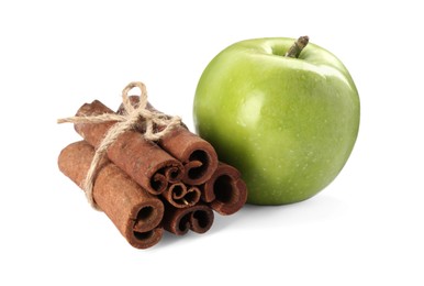 Cinnamon sticks and green apple on white background