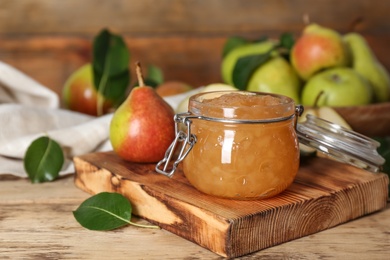 Delicious pear jam and fresh fruits on wooden table. Space for text