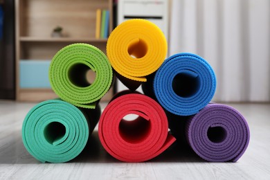 Bright rolled camping mats on white wooden floor indoors