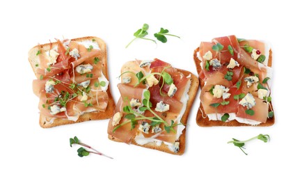 Delicious sandwiches with prosciutto, microgreens and cheese on white background, top view