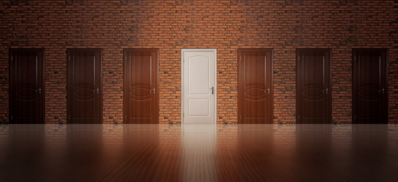 Image of White door among brown ones in room. Concept of choice