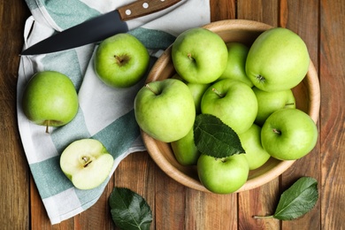 Fresh ripe green apples and knife on wooden table, flat lay