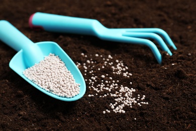 Gardening tools and chemical fertilizer on soil