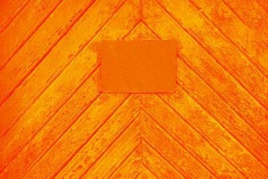 Textured orange wooden surface with stained signboard as background