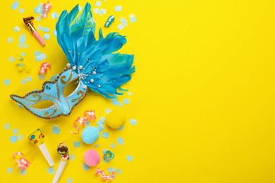Flat lay composition with carnival items on yellow background. Space for text
