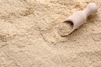 Photo of Wooden scoop of brewer`s yeast on flakes, closeup