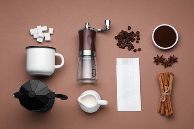 Photo of Flat lay composition with manual coffee grinder and spices on brown background