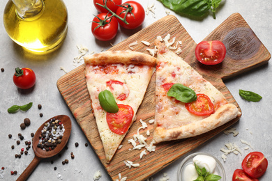 Slices of delicious pizza Margherita on light grey table, flat lay