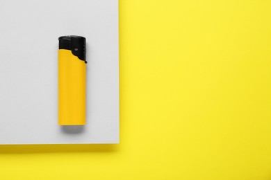 Photo of Stylish small pocket lighter on color background, top view. Space for text
