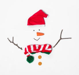 Creative snowman shape made of Santa hat and different items on white background, flat lay