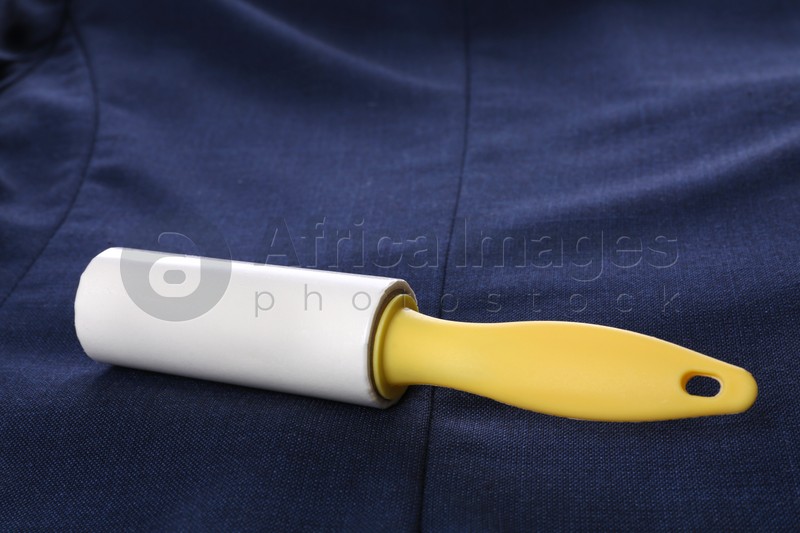 Photo of New lint roller with yellow handle on blue jacket