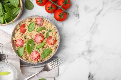 Photo of Delicious quinoa salad with tomatoes, beans and spinach leaves served on white marble table, flat lay. Space for text