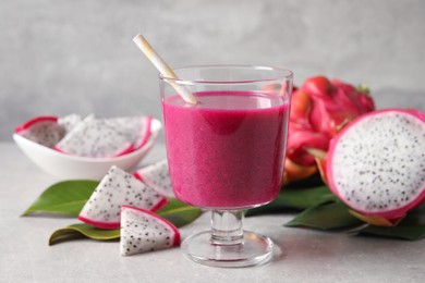 Delicious pitahaya smoothie and fresh fruits on light grey table