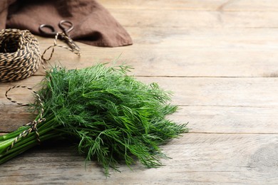Bunch of fresh dill on wooden table, space for text