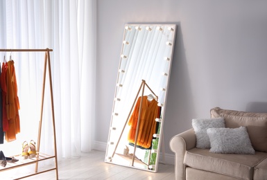 Full length dressing mirror with lamps in stylish room interior