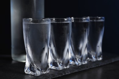 Set of glasses with vodka on black table, closeup