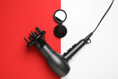 Hair dryer and brush on color background, flat lay. Professional hairdresser tool