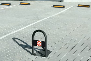 Photo of Parking barrier with No Stopping road sign on pavement outdoors, space for text